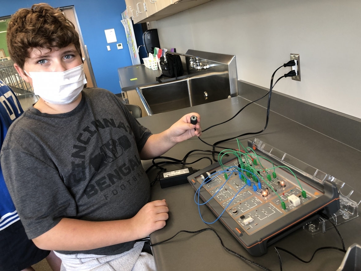 Student wearing mask working on electrical board