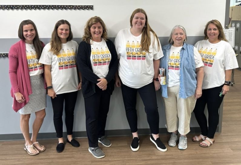 Group of staff wearing matching "Fifth Grade" t-shirts