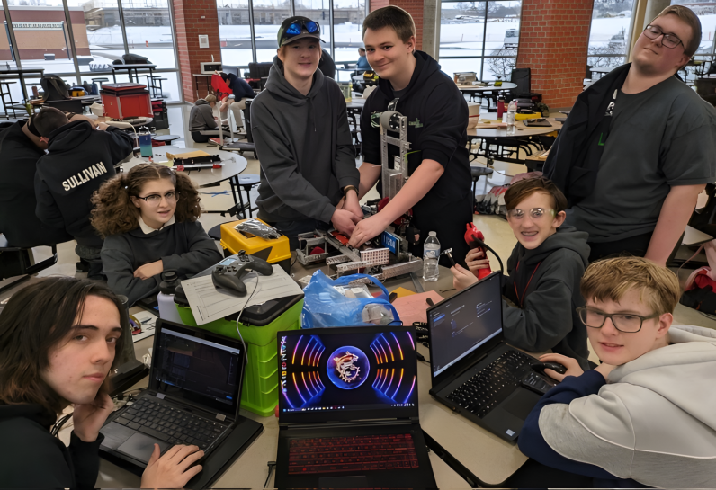 group of students at computers and building mechanical items